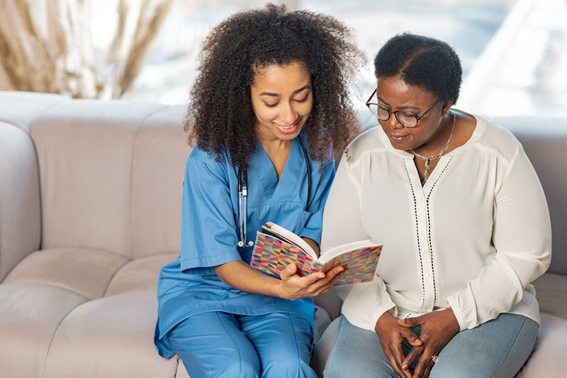 A nurse spending time with a patient in her room at Spring Lake Skilled Nursing & Rehabilitation in Shreveport, LA.