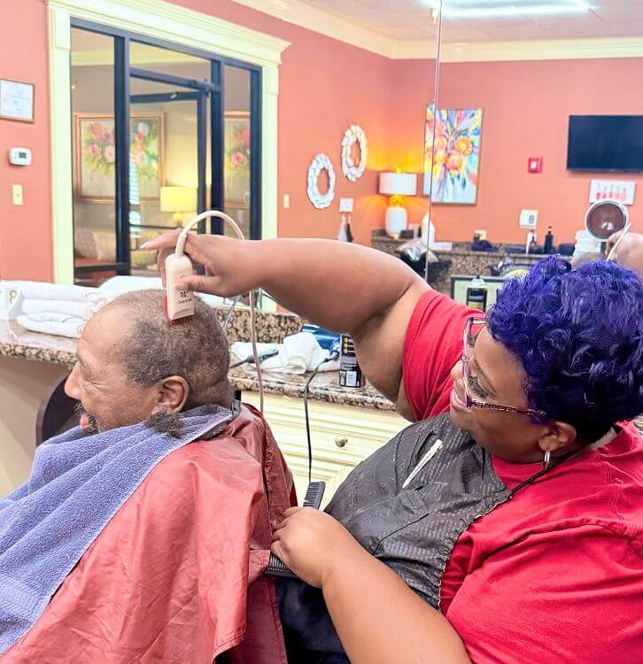 An elderly man receiving an expert haircut at Spring Lake Skilled Nursing & Rehabilitation in Shreveport, LA